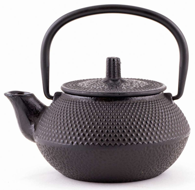 A black cast iron teapot with a removable strainer basket.