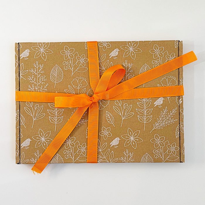 Gift box with floral pattern and orange ribbon on a white background