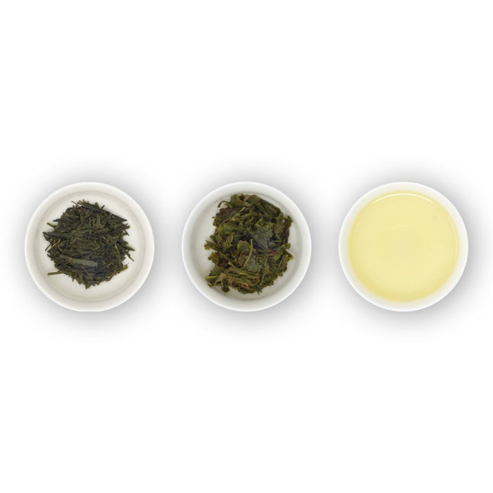 Three white bowls containing loose green tea leaves, with the bowl on the right showing the brewed tea.