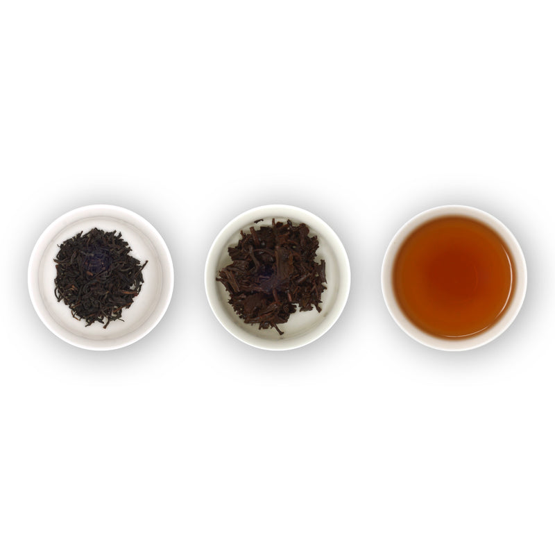 Three white bowls containing loose tea leaves and brewed tea, arranged in a row on a white background.