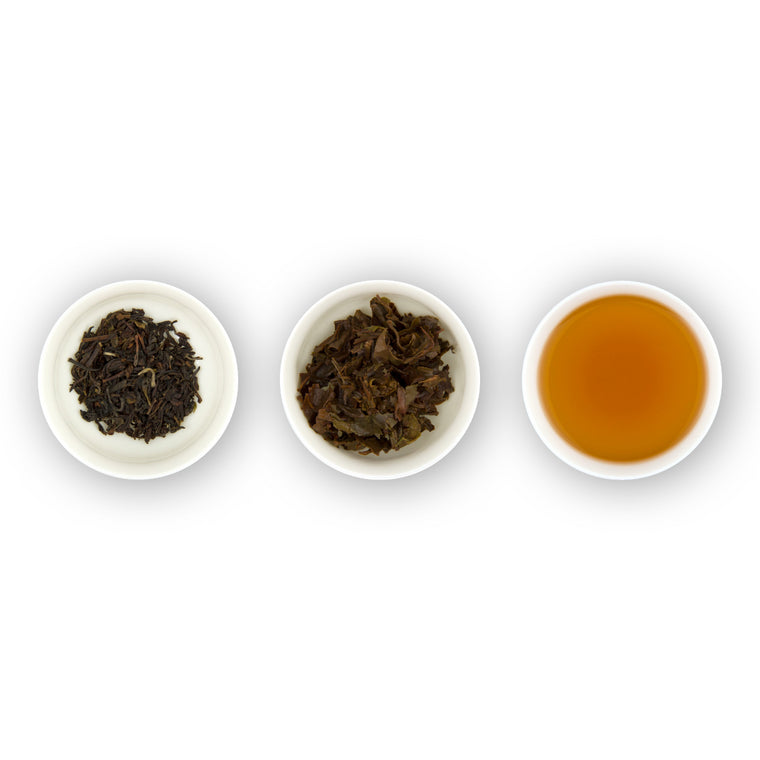 Three circular bowls with samples of Earl Grey tea. The first bowl shows dry loose black tea leaves with blue flower petals, the second bowl shows the tea leaves after brewing, and the third bowl shows the brewed tea liquid.
