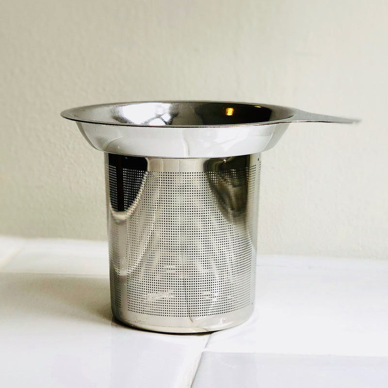 A stainless steel tea strainer basket designed to fit in a mug or teapot.