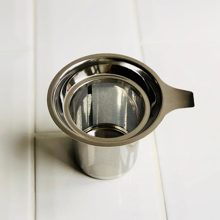 An overhead shot of a tea strainer (infuser) basket made from stainless steel