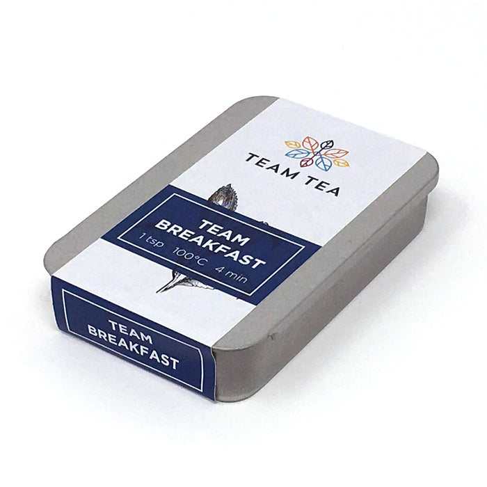 A metal tin of loose black tea with a sliding lid and paper label. The text on the label reads Team Breakfast