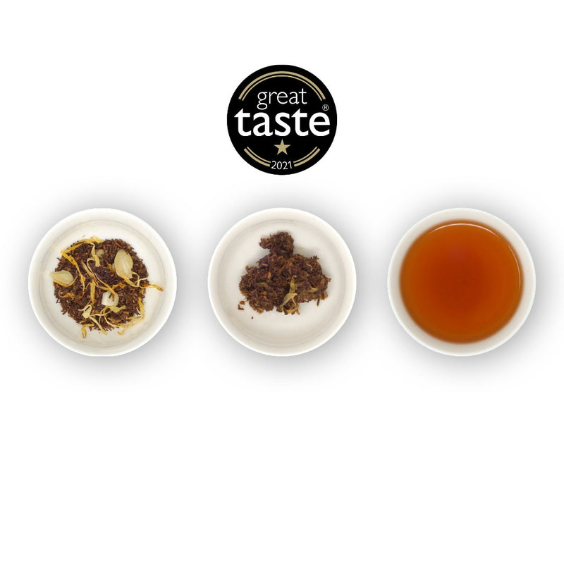 Three circular bowls showcasing loose tea leaves of rooibos, with the right bowl having a brewed tea sample, and the 'Great Taste' award seal at the top.