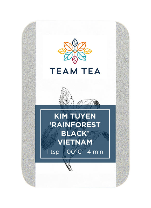 A metal tin containing loose-leaf black tea. The tin has a blue label with a botanical sketch of tea leaves and the Team Tea logo