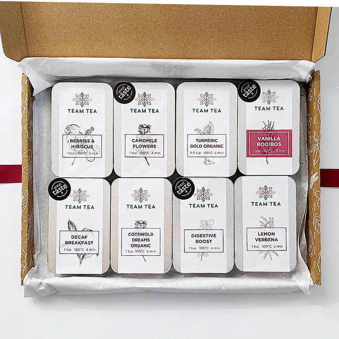 Box of Team Tea slide tins with various tea flavours on a white background