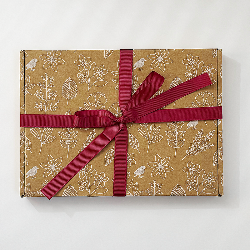 Gift box with floral pattern and red ribbon on a white background