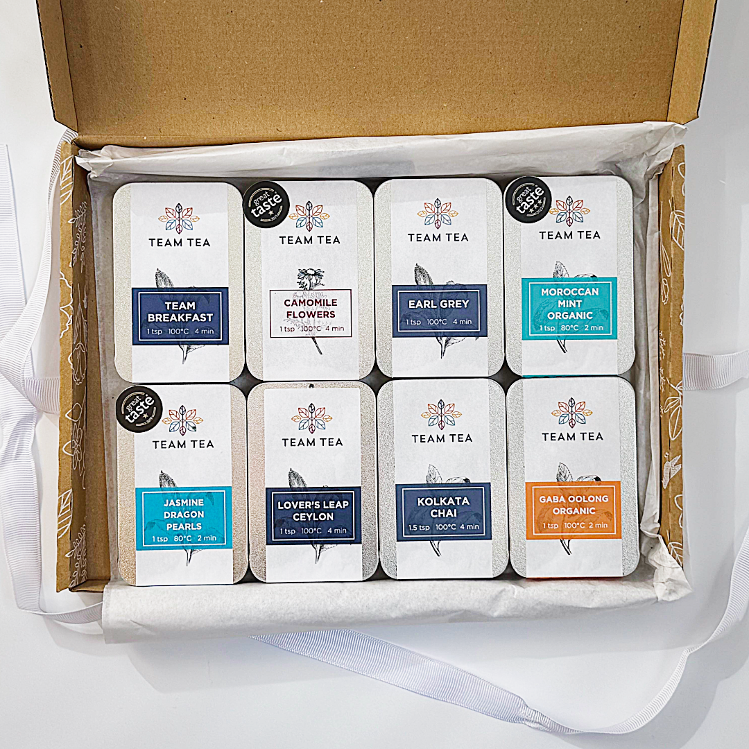 Box of Team Tea slide tins on a white background
